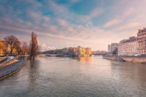 Edifici residenziali storici situati sulla riva del fiume increspato che scorre a Parigi nella sera d'inverno — Foto stock