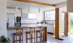Ecke der stilvollen Küche mit weißen und gemauerten Wänden, Holzboden, Holzarbeitsplatten — Stockfoto