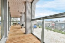 Balkoninnenraum mit Holztisch gegen Fenster und Säulen unter der Decke zu Hause — Stockfoto