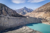 Paysage de lac bleu entouré de montagnes rocheuses avec des pentes raides dans une vaste vallée au Népal — Photo de stock