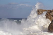 Desde arriba espectacular paisaje de poderosas olas marinas espumosas salpicando cerca de escarpados acantilados rocosos en Bufones de Pria Asturias España - foto de stock