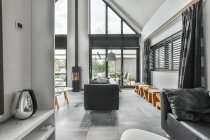 Interieur von stilvollen geräumigen grauen Wohnzimmer mit bequemen Sofas in der Nähe von Glastüren eingerichtet — Stockfoto