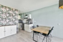 Interior da cozinha contemporânea com mesa de jantar de madeira e eletrodomésticos em novo apartamento — Fotografia de Stock