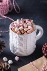 Dall'alto di tazza di ceramica con cacao dolce con marshmallows vicino a coni di abete e corda per legare regali di Natale — Foto stock