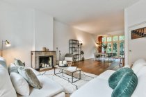 Interior de salão espaçoso com lareira e confortável sofá e poltronas na casa contemporânea — Fotografia de Stock