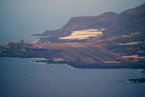 Kleiner Flughafen direkt am Meer gebaut und von Bergen mit Häusern und Bananenplantagen umgeben. Cumbre Vieja Vulkanausbruch auf La Palma Kanarische Inseln, Spanien 2021 — Stockfoto