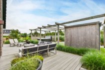 Hinterhof der Villa mit Holzmöbeln und Whirlpool inmitten von Pflanzen in ländlicher Nachbarschaft — Stockfoto