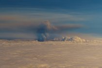 Mar de nubes desde arriba y al fondo un humo negro producido por un volcán.. Cumbre Vieja erupción volcánica en La Palma Islas Canarias, España, 2021 - foto de stock