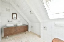 Modernes Badezimmerinterieur mit Räucherstäbchen im Regal gegen Waschbecken zwischen Schränken und Spiegeln im Leuchtturm — Stockfoto