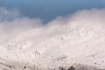 Severe mountain slope covered with snow and clouds in cold winter day in Sierra de Guadarrama National Park — Stock Photo
