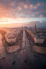 Vista drone de fachadas de casas urbanas e estradas com transporte sob céu nublado brilhante ao pôr do sol em Paris França — Fotografia de Stock