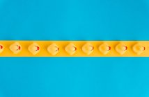 De dessus ensemble de canetons en caoutchouc mignons jouets dans une rangée placée sur fond bleu vif et jaune — Photo de stock