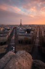Вид на фасады городских домов и проезжие части с транспортом под блестящими облаками на закате солнца в Париже Франция — стоковое фото