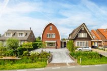 Асфальт проклав шлях до житлових будинків і луків з деревами під хмарним небом в Утрехті (Нідерланди). — стокове фото