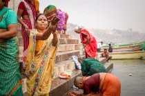 INDIA, VARANASI - 27 DE NOVIEMBRE DE 2015: Mujer étnica en ropa tradicional y vendedoras tradicionales indias en ropa tradicional y sombreros cónicos tradicionales indios con ritual - foto de stock