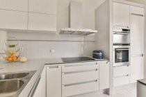 Design creativo della cucina con fornello elettrico e armadio sopra frutta fresca in casa luce — Foto stock