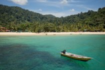 Landschaft aus klarem, transparentem Meerwasser mit Booten am Sandstrand und exotischem Regenwald in Malaysia — Stockfoto
