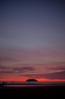 Vista panoramica del mare infinito con i turisti passeggiando sulla riva sabbiosa al tramonto in Malesia — Foto stock