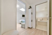 Кровать под блеском на фоне современной ванной комнаты с ванной и шкафом на плиточном полу дома — стоковое фото