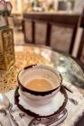 Tazza di caffè aromatico in ceramica sul tavolo con tovaglioli in caffetteria — Foto stock