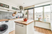 Interno di spaziosa cucina con elettrodomestici contemporanei e mobili bianchi in appartamento progettato in stile minimale — Foto stock