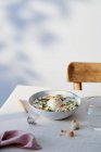 Alto angolo di ciotola in ceramica con uova turche poste sul tavolo vicino a vetro di acqua e forchetta — Foto stock