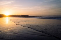 Сценічний вигляд хвилястого океану і пляжу Фамара проти гір при заході сонця в Тегіз Лансароте Канарські острови Іспанія — стокове фото