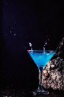 Verre de Blue Lagoon cocktail alcoolisé posé sur pierre brute dans un studio lumineux — Photo de stock
