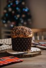 Panettone dolce fatto in casa su un supporto di legno rotondo vicino al coltello per festeggiare il Natale — Foto stock