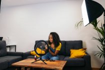 Afro-americano signora dimostrando polvere tavolozza durante vlog registrazione tramite cellulare su LED anello lampada — Foto stock