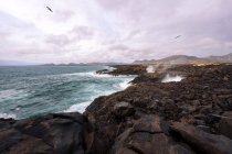 Сценічний вид на пінявий океан проти пляжу Циклос і вулкану Гінчо на Гольфо Яіза Лансароте Канарські острови Іспанія — стокове фото