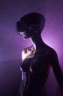 Жіночий манекен з VR окулярами, розміщений на яскраво-фіолетовому фоні як символ футуристичної технології — стокове фото