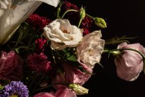 Bouquet de fleurs fraîches dont lys blancs eustoma et aster dans un vase en verre au soleil — Photo de stock