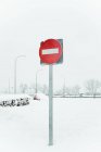 Sinal de trânsito vermelho que proíbe a entrada no posto na neve perto da estrada no dia de inverno em Madrid — Fotografia de Stock