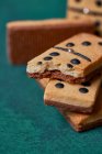 Heap de doces saborosos dominós crocantes em forma de biscoitos com pontos pretos e pedaço mordido espalhados na superfície verde na sala de luz — Fotografia de Stock