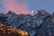 From below of amazing scenery of moon in dark sky over rocky highlands in evening in Sierra de Guadarrama National Park in Spain — Stock Photo