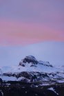 Paysage pittoresque de montagnes rocheuses avec des sommets enneigés contre un incroyable coucher de soleil rose en Islande — Photo de stock