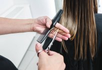 Coltiva un parrucchiere irriconoscibile usando le forbici per tagliare i capelli biondi del cliente nel salone di bellezza — Foto stock