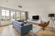 Bequemes Sofa und Sessel in der Nähe von TV gegen Fenster und Tür im Wohnzimmer des modernen Anwesens — Stockfoto