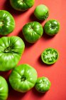 De arriba de los tomates verdes enteros de guinda en la escudilla recogida en la granja durante la temporada de la cosecha - foto de stock