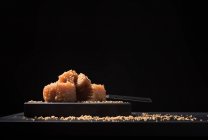 Изысканный айва желе паста в керамической пластины посыпать кунжутом семян на черном фоне — стоковое фото