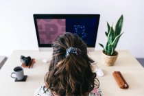 From above of female designer using contemporary computer while working in modern office — Stock Photo