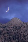 From below of amazing scenery of crescent moon in dark sky over rocky highlands in evening in Sierra de Guadarrama National Park in Spain — Stock Photo