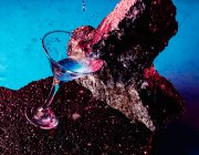 Сверху бокал алкогольного коктейля Blue Lagoon помещен на грубый камень в яркой студии — стоковое фото