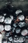Vue de dessus du morceau de glace avec des raisins placés sur un plateau métallique à la lumière du soleil — Photo de stock