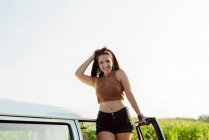 Belle et heureuse fille brune debout sur un van par une journée ensoleillée — Photo de stock