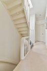 Treppe im schmalen Flur mit Lampe und Spiegel, die an sonnigen Tagen ins Schlafzimmer in der gemütlichen Wohnung führt — Stockfoto