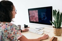 Von oben von der Designerin, die zeitgenössische Computer benutzt, während sie im modernen Büro arbeitet — Stockfoto