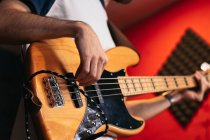 Gestutzter, bis zur Unkenntlichkeit verkleideter Mann im lässigen Outfit spielt Bassgitarre in leichtem Club — Stockfoto