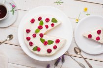 Von oben leckerer gesunder Keto-Crepe-Kuchen mit Erythrit-Süßstoff, dekoriert mit reifen Himbeeren, serviert auf Holztisch mit dekorativen Zweigen in der Küche — Stockfoto
